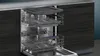 The interior of a dishwasher with multiple racks extended. Produktbild-Vorschau