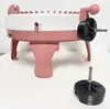 A pink and white knitting machine adapter with a separate black attachment on a white surface. Produktbild-Vorschau