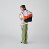 A young person wearing a backpack, posing for a product shot. Náhled obrázku produktu