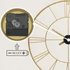 Close-up of a clock mechanism and battery compartment with an illustration of a battery. Voir les images du produit