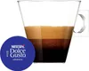 A glass cup filled with coffee and a coffee capsule next to it. Produktbild-Vorschau