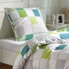 A close-up view of bedding on a bed, featuring a pillow and a duvet with a checkered pattern. Produktbild-Vorschau