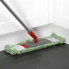 A mop with a green chenille microfiber head is being used to clean a corner where the floor meets the wall. Produktbild-Vorschau
