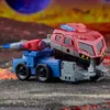 A toy robot in vehicle mode is displayed on a rocky, alien-like surface with a large planet in the background. Anteprima dell’immagine prodotto