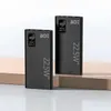 Two black power banks are displayed on a light brown surface against a white background. Produktbild-Vorschau