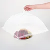 A hand holding a white mesh food cover over a plate of fruit. Produktbild-Vorschau