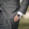 A man in a suit with his hand in his pocket, showing off his watch. Produktbild-Vorschau