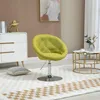 A lime green accent chair is placed on a rug in a room with a white dresser and a round coffee table. Produktbild-Vorschau