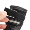 A close-up of a black dog boot with a hand holding open a velcro strap. Produktbild-Vorschau