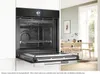 An open built-in oven with a microwave function is shown in a modern kitchen setting, with a dining area visible in the background. Produktbild-Vorschau
