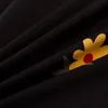 A close-up view of black fabric with a floral pattern. Produktbild-Vorschau