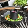 A cast iron chicken roaster with vegetables and red wine being poured into the aroma cone, placed on a grill. Anteprima dell’immagine prodotto
