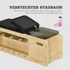 A close-up view of a wooden fitness bench with a black padded seat and a transparent storage compartment. A pink water bottle and towel are placed next to the bench. Náhľad obrázku produktu