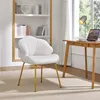 A white upholstered chair with gold legs sits in a room with a bookshelf and a desk. Produktbild-Vorschau