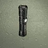 A black National Geographic flashlight is shown on a wet, textured surface. Produktbild-Vorschau