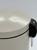 A close-up view of the lid and side of a sand-colored trash can, showing the pedal mechanism. Náhled obrázku produktu