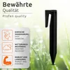 A black plastic ground stake is shown in a grassy, dewy environment, with text overlays highlighting product features. Podgląd zdjęcia produktu