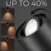 Close-up of a black spotlight with a bright LED bulb, with smaller inset images showing the light beam on a wall and text indicating a discount. Náhled obrázku produktu