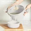 A person is pouring liquid from a pot into a bowl, demonstrating the pouring spout feature. Produktbild-Vorschau