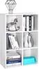 A white cube shelf unit filled with various decorative items and books. Voir les images du produit