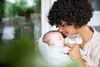 A mother is feeding her baby with a bottle. Produktbild-Vorschau