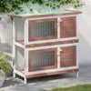 A two-tier rabbit hutch with wooden doors and wire mesh windows, set against a white wall with ivy and on a paved patio. Produktbild-Vorschau
