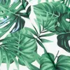 A close-up view of a fabric with a tropical leaf pattern. Produktbild-Vorschau