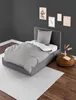 A bedroom scene with a single bed, bedding, and decorative items. Produktbild-Vorschau
