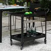 An outdoor serving cart with bottles of water and fruit on it, placed on a gravel patio next to a table. Náhled obrázku produktu