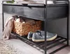 A close-up view of a storage bench in a hallway or entryway, showing shoes on the bottom shelf and a basket with blankets on the middle shelf. Produktbild-Vorschau