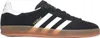 A side view of a black Adidas Gazelle sneaker with white stripes and a gum sole. Produktbild-Vorschau