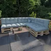An outdoor seating area with a sectional sofa made of pallets and blue cushions, a coffee table, and a rug. Voir les images du produit
