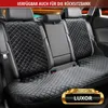 The image shows the interior of a car with a black quilted seat cover on the rear seats. Produktbild-Vorschau