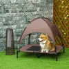 A corgi dog sits on an elevated dog bed with a canopy, placed on artificial grass in an outdoor setting. Produktbild-Vorschau