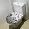 A white toilet with a toilet seat cover that has a water droplet design, set in a bathroom with tiled walls and floor. Produktbild-Vorschau