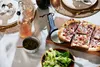 A table setting with pizza, salad, and drinks. Anteprima dell’immagine prodotto