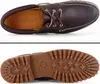 A top-down view of a pair of brown leather boat shoes and a bottom view of the sole of the shoe. Anteprima dell’immagine prodotto