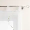 A close-up view of a white sheer curtain with green embroidery, hanging from a silver curtain rod. Produktbild-Vorschau