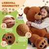 A young girl hugging a large teddy bear, surrounded by marketing graphics highlighting product features. Anteprima dell’immagine prodotto