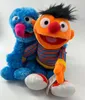 Two plush toys, Ernie and Grobi, are sitting side-by-side against a white background. Produktbild-Vorschau