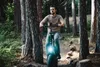 A man is riding an electric fat bike on a dirt path in a forest. Produktbild-Vorschau
