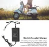 A person is sitting on a scooter, with a charger in the foreground. Anteprima dell’immagine prodotto