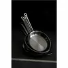 A stack of stainless steel frying pans on a dark surface with dramatic lighting. Produktbild-Vorschau