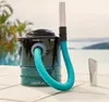 A vacuum cleaner is placed on a tiled surface next to a swimming pool with a body of water and trees in the background. Anteprima dell’immagine prodotto