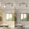 A split image showing a ceiling light fixture with two lights, one set to 'on' and the other to 'off'. The 'on' side shows a warm light, while the 'off' side shows a cooler, brighter light. The background is a bedroom with a window and blinds. Produktbild-Vorschau
