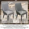 Two chairs are shown side-by-side to illustrate how lighting affects their color. The background shows a dining room setting. Voir les images du produit
