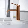 A modern copper faucet in a bathroom sink with water running. Produktbild-Vorschau