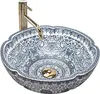 A decorative ceramic sink with a gold faucet. Náhled obrázku produktu