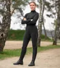 A woman in riding attire stands outdoors with trees in the background. Náhled obrázku produktu