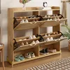 A wooden shoe cabinet with multiple shelves and doors, filled with shoes, placed in a room. Anteprima dell’immagine prodotto